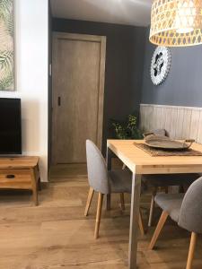 a dining room with a table and chairs and a television at Apartament Neret II in Sort
