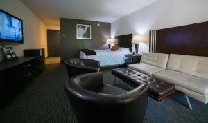 um quarto de hotel com uma cama e uma sala de estar em Lemon Tree Inn em Santa Bárbara