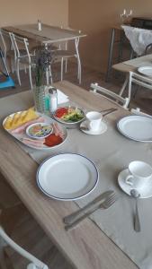 una mesa con platos blancos de comida. en Berény Panzió, en Balatonberény