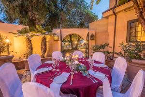 a table with white chairs and a red table cloth at Historic Santa Maria Inn in Santa Maria