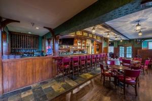 un restaurante con sillas rojas y un bar en Historic Santa Maria Inn en Santa Maria