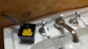 un lavabo con un jarrón con una flor amarilla. en My Ponte Vecchio apartment, en Florencia 15 fotos más