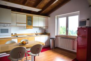 cocina con mesa de madera, sillas y ventana en J&J House, en Castelmarte