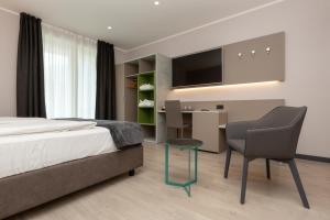 a bedroom with a bed and a desk and a chair at Garda Life in Riva del Garda