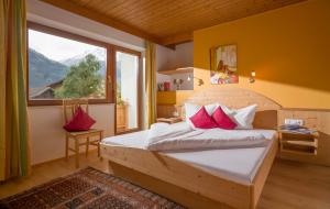 a bedroom with a bed and a large window at Landhaus Gasser in Mayrhofen