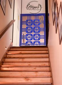 Un escalier mène à une porte bleue et blanche. dans l'établissement Cooper Hotel Boutique, à Cusco