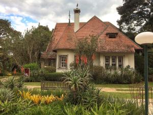 a small white house with a red roof at Apto Itaipava Granja Brasil in Itaipava