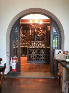 an archway leading to a wine cellar with wine bottles at Apto Itaipava Granja Brasil in Itaipava