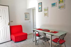 a red chair and a table in a room at Sa Teria Village - Appartamenti - in Tertenìa