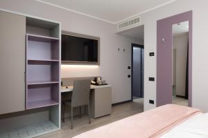 a bedroom with a desk and a tv and a bed at Garda Life in Riva del Garda