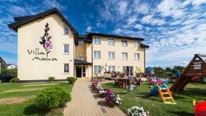 a building with a playground in front of it at Villa Malva in Karwia