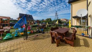 a playground with a wooden table and chairs next to a fence at Villa Malva in Karwia