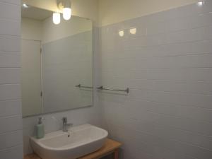 een witte badkamer met een wastafel en een spiegel bij Oporto City Cottage in Porto +45 foto's