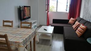 sala de estar con sofá, mesa y TV en casa quintana, en Arinaga