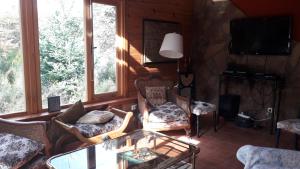 uma sala de estar com uma mesa de vidro e cadeiras em Lo De Pablo em Villa La Angostura
