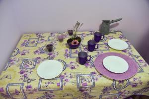 a table with white plates on a floral table cloth at PRENOĆIŠTE PILOT in Niš