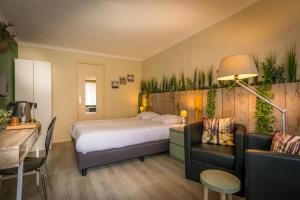um quarto de hotel com uma cama, uma mesa e cadeiras em Carré Hotel Zuid-Limburg em Hulsberg