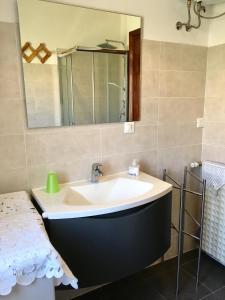 W łazience znajduje się umywalka i lustro. w obiekcie Casa Smeraldo w mieście Loano