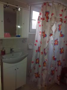 a bathroom with a sink and a shower curtain at Maria Charalampaki Studios in Skiros +49 photos