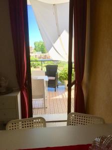 a view of a patio through a window with chairs at Casa Smeraldo in Loano