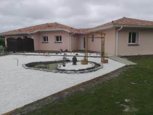 ein Haus mit einem Brunnen in der Mitte eines Gartens in der Unterkunft villa lou miquéou in Lit-et-Mixe