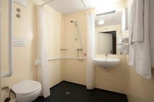 a bathroom with a toilet and a sink at Gasthaus Mooshäusl in Hebertshausen