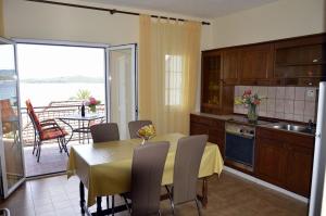 a kitchen and dining room with a table and a balcony at Apartments Zdravko - comfortable & close to the sea in Orebić