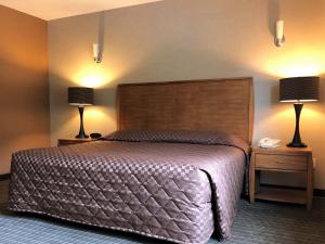 um quarto com uma cama grande e 2 candeeiros em Breeze Inn Motel em Seward