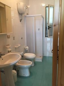 ガリポリにあるBaia Verde Biloの白いバスルーム(トイレ2つ、シャワー付)