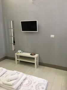 ガエータにあるAlmayer al Duomoのベッド1台と壁掛けテレビが備わる客室です。