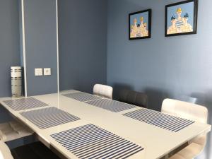 a table in a room with two pictures on the wall at Appartement Face à la mer in Wimereux
