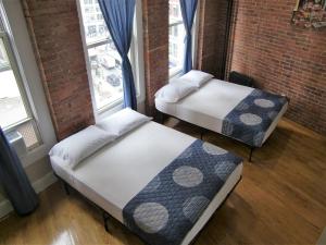 2 Betten in einem Zimmer mit 2 Fenstern in der Unterkunft Studios Midtown Manhattan in New York