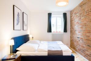 a bedroom with a bed and a brick wall at Ferienwohnungen im Alten Backhaus in Haselberg