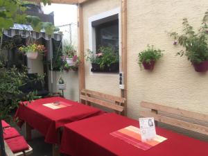 2 Tische mit roten Tischdecken auf einer Terrasse in der Unterkunft Ferienwohnungen Calwer Höfle - für Firmen, Handwerker und Monteure in Calw