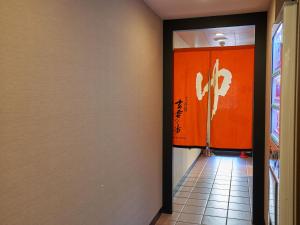 a hallway with an orange wall in a building at APA Hotel Naha Matsuyama in Naha