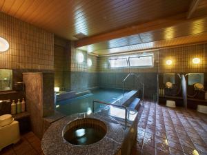 a large bathroom with a swimming pool and a tub at APA Hotel Naha Matsuyama in Naha