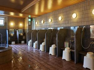 baño con una fila de urinarios en una habitación en APA Hotel Naha Matsuyama, en Naha