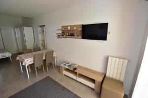 a living room with a table and a tv on a wall at Apartments and Room in Nature Setting in Matulji