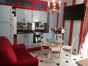 a living room with a table and a red and white kitchen at Rodeo Drive in Viareggio