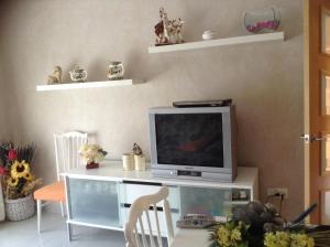 a living room with a tv on a table at La torre in Rodonyà