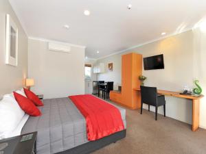 a bedroom with a large bed and a desk and a desk at Mohua Motels in Takaka