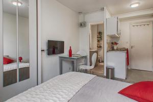 a bedroom with a bed and a desk and a refrigerator at Studio Cosy + Hyper-centre + Netflix in Saint Lo