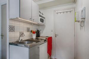 a small kitchen with a sink and a microwave at Studio Cosy + Hyper-centre + Netflix in Saint Lo