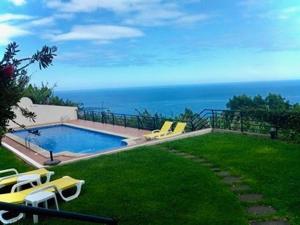 a swimming pool with a view of the ocean at Jardim do Arco "Esmee" in Arco da Calheta