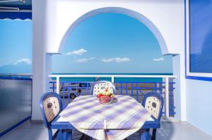 a table with chairs and a bowl of fruit on a balcony at House Katerina Mediterranean in Sarti