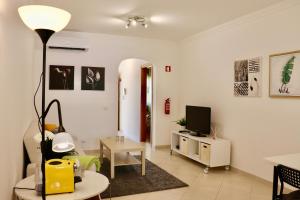 a living room with a couch and a tv in it at Algarve Sweet Home - Sea View in Armação de Pêra