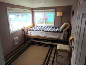 Historic 1920s Cabin في لونغ بيتش: غرفة نوم صغيرة بها سرير ونوافذ