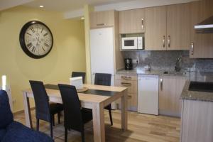 a kitchen with a table and a clock on the wall at Casa Santiago in Comillas