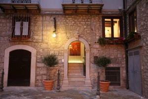 um edifício de pedra com uma porta e dois vasos de plantas em B&B Al Convento em Potenza