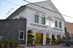 a white building with plants in front of it at HOTEL SHAFURA 1 in Cukai